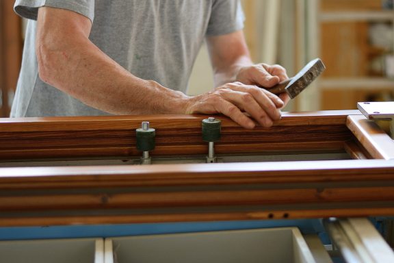 Handwerker am Holzfenster